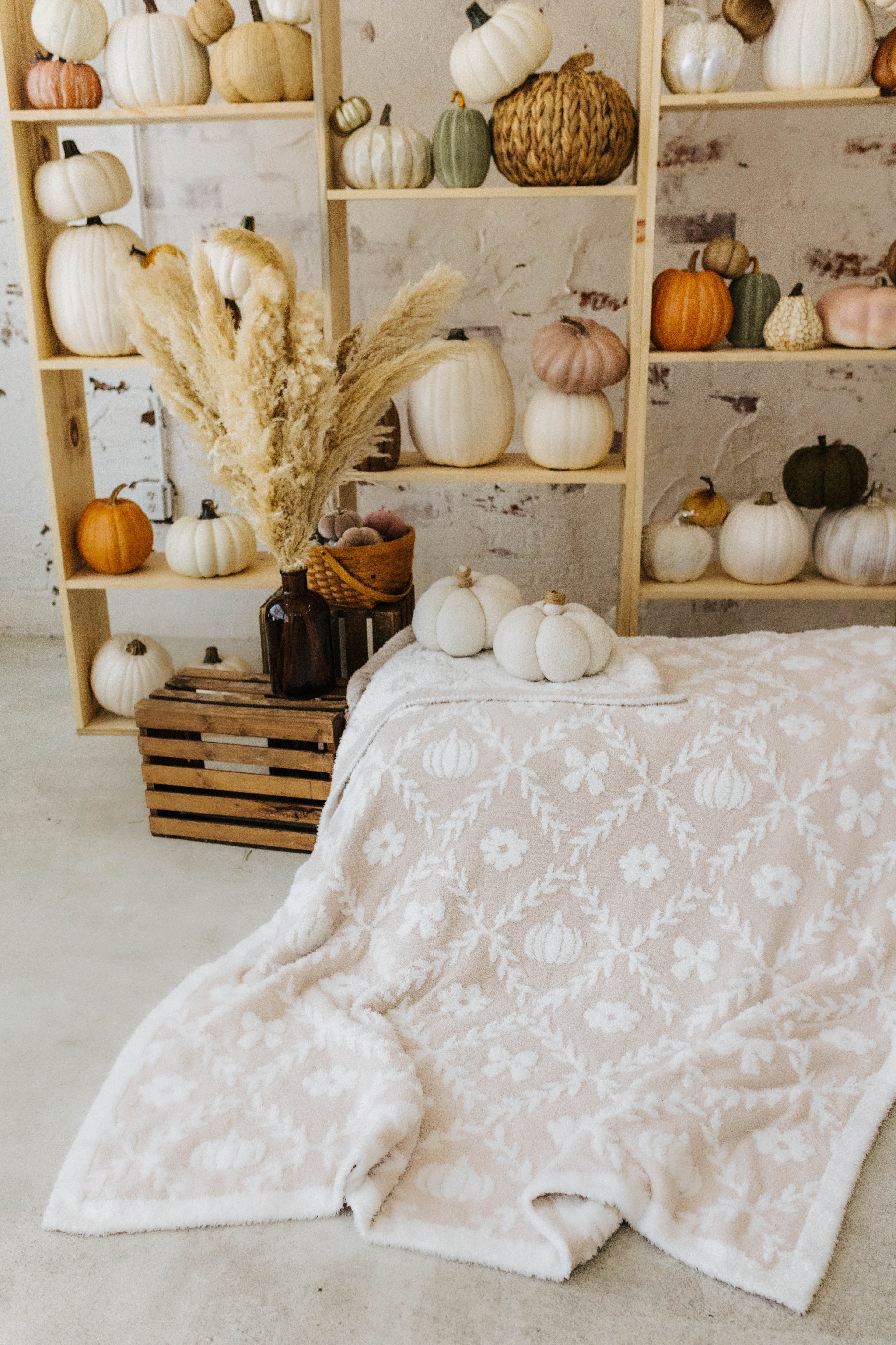pumpkin blanket laid out with pumplin decorations in the background 