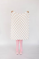 Checkered blanket with pink tights and shoes on a plain background