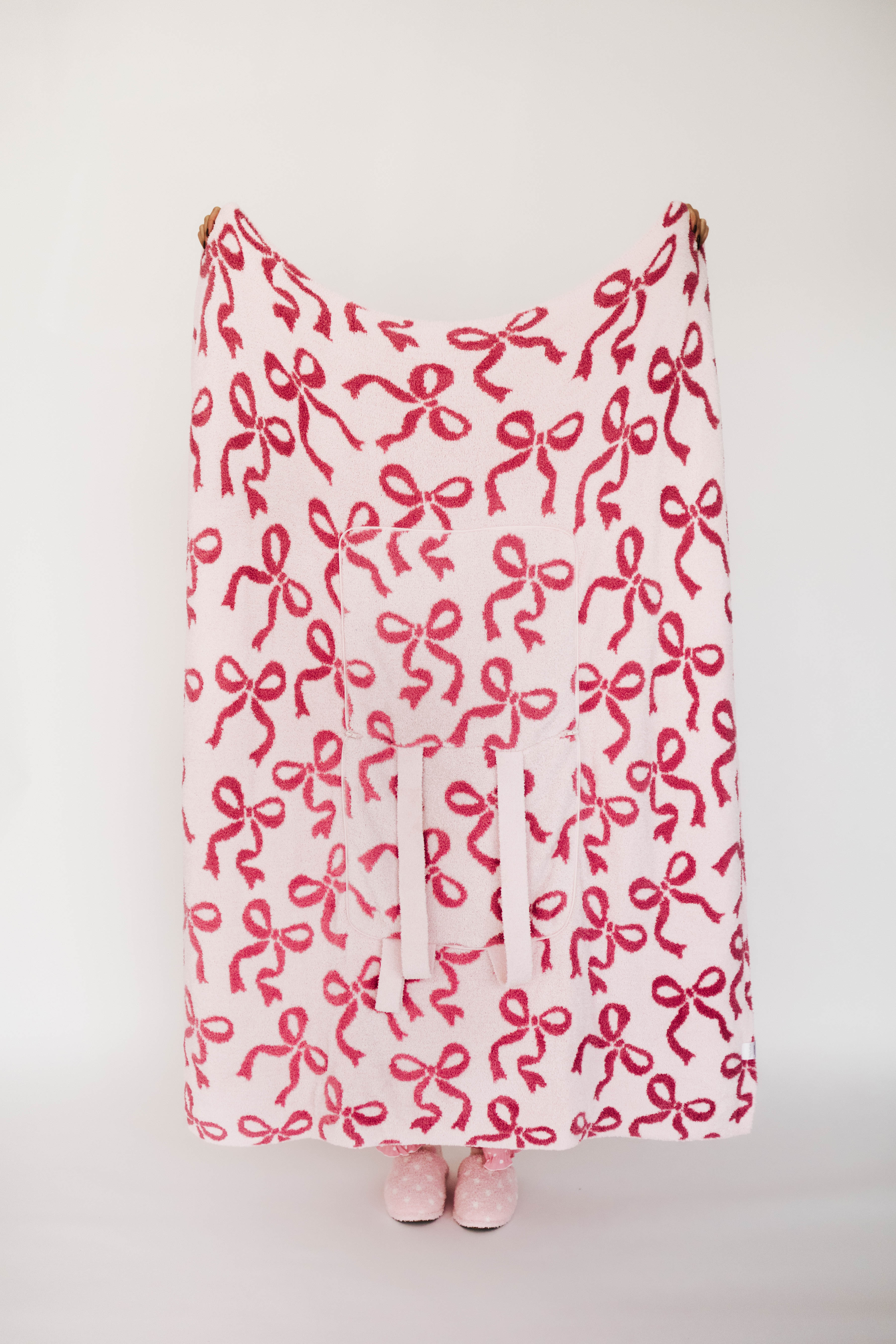 Pink blanket with bow pattern on a white background