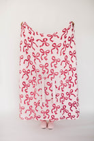 Pink blanket with bow pattern on a white background