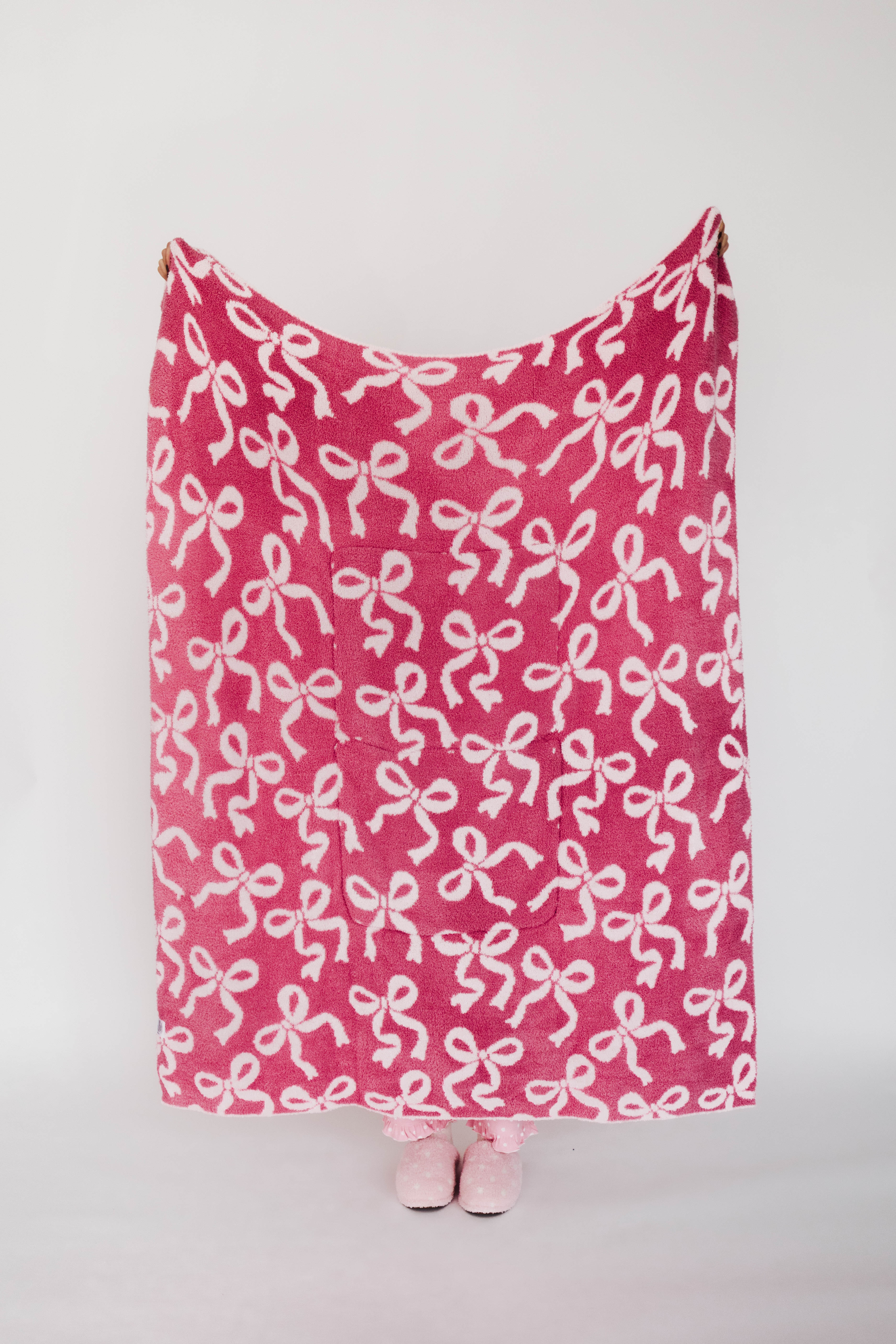 Pink blanket with bow pattern on a white background