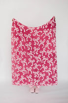 Pink blanket with bow pattern on a white background