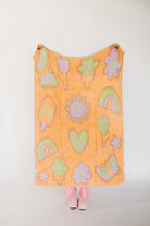 Orange blanket with colorful patterns on a white background