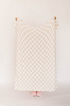 Checkered blanket against a white wall