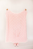 Pink polka dot blanket with matching slippers on a white background