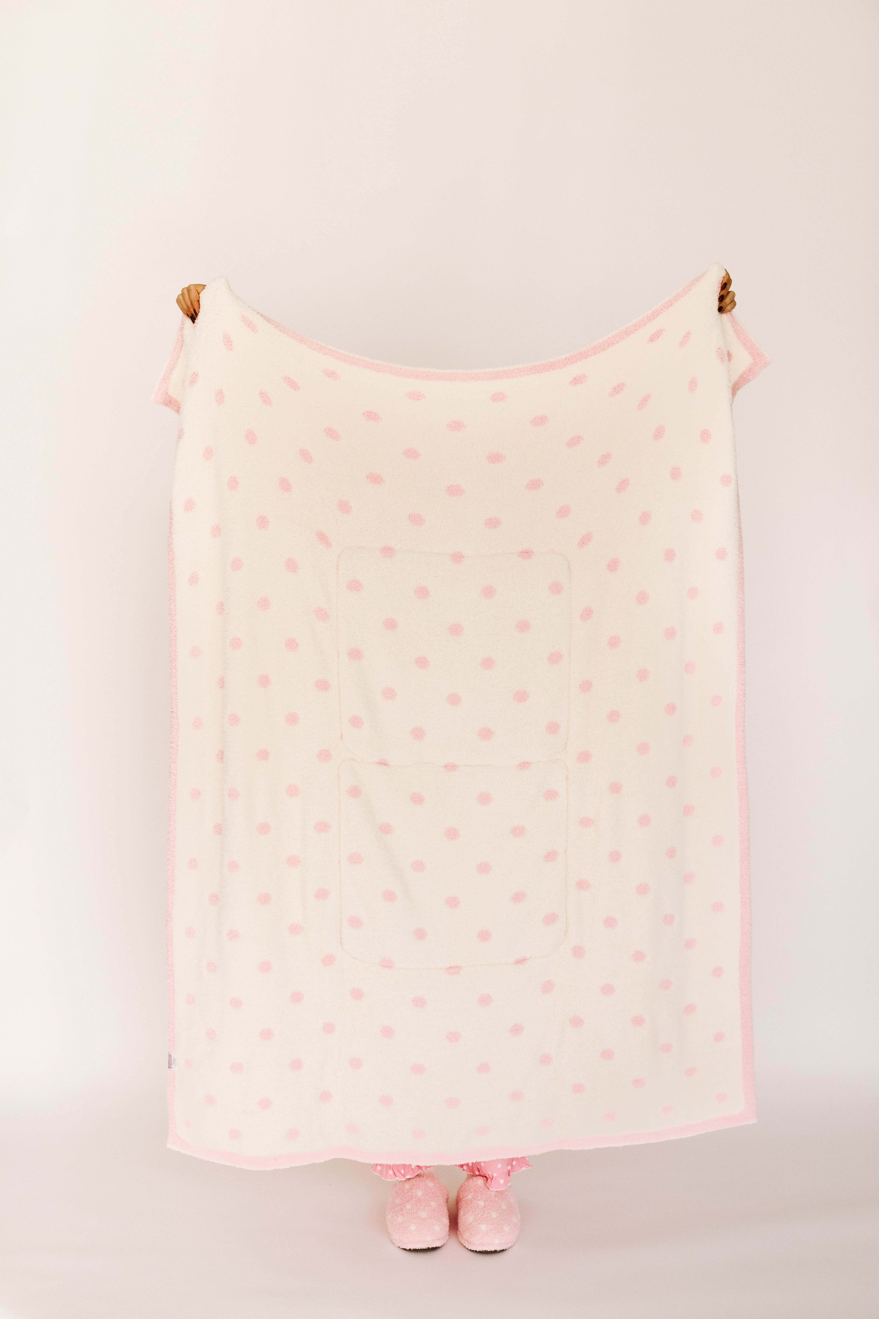 Pink polka dot blanket against a white background