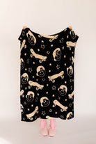 Black blanket with beige skateboards and smiley faces on a plain background