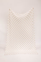 Checkered fabric with beige and white pattern on a white background