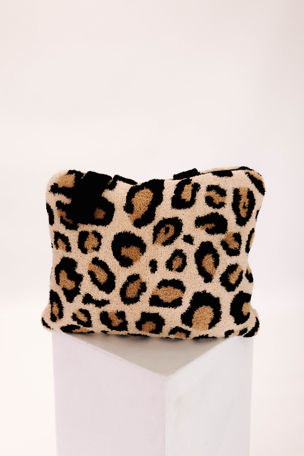 Leopard print quillow on a white surface with a white background