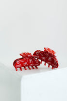 Red hair clips with bow pattern on a white background