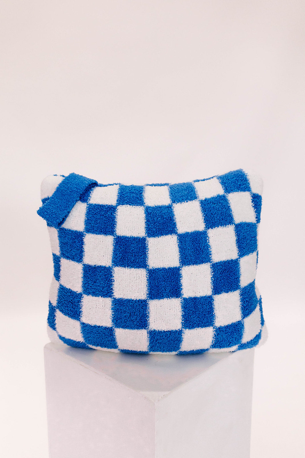 Blue and white checkered pillow on a white background