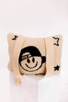 Beige quillow with a smiley face design on a white background