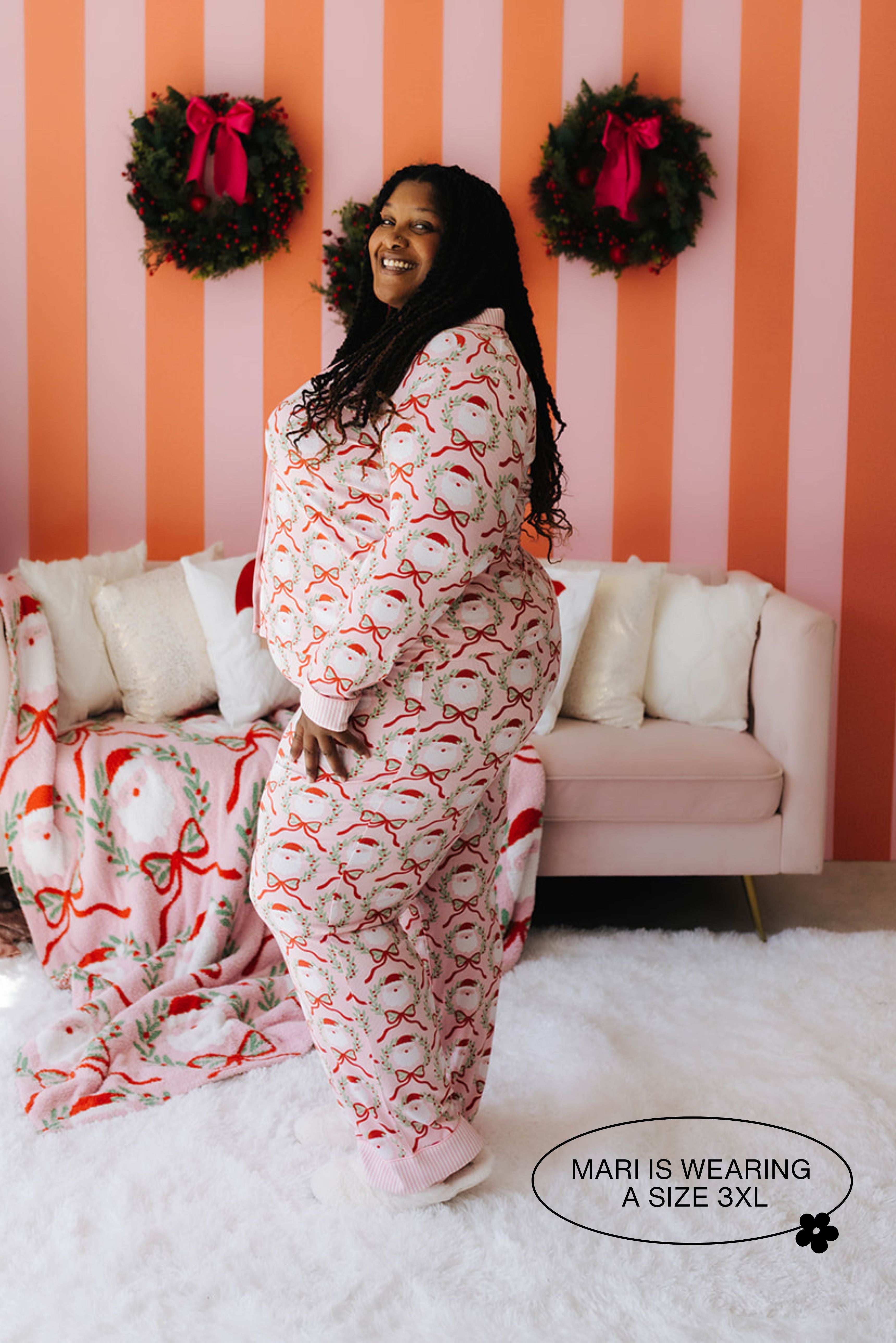 Woman wearing a festive onesie in a room with striped walls and a couch.