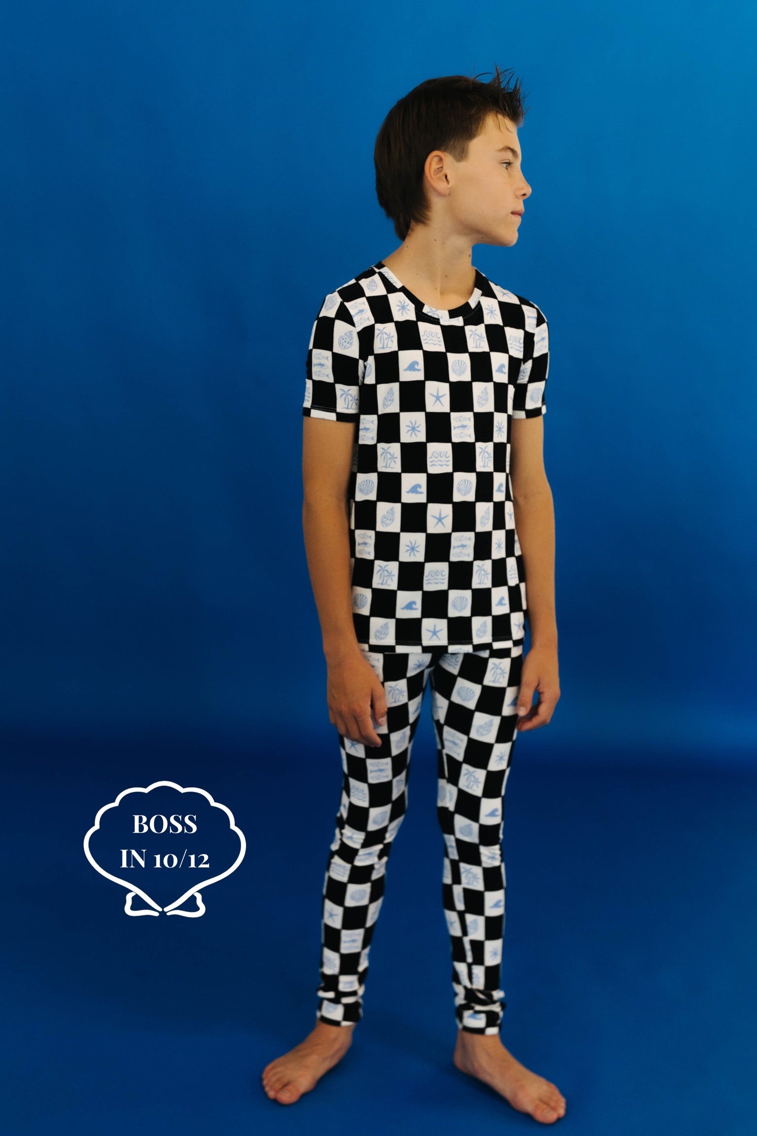 Child wearing a black and white checkered pj set on a blue background size 10/12
