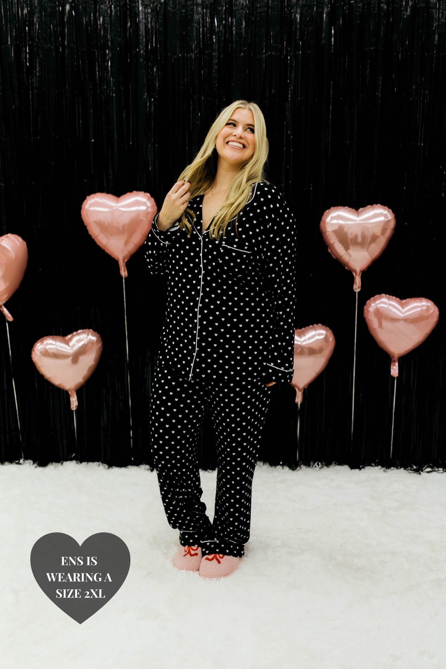 Ens smiling and looking up while holding her blonde hair - wearing the 2xl