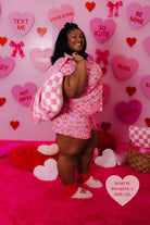 Mari smiling while holding the pink tonal check quillow on her hand and thrown over her shoulder - wearing the size 3xl 