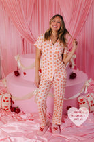 Bri in the size XS pjs standing in front of the cake smiling