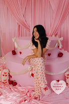 Lynds sitting on the cake smiling and looking to the side