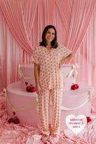 Krista standing in from the cake smiling with one hand on her hip size L