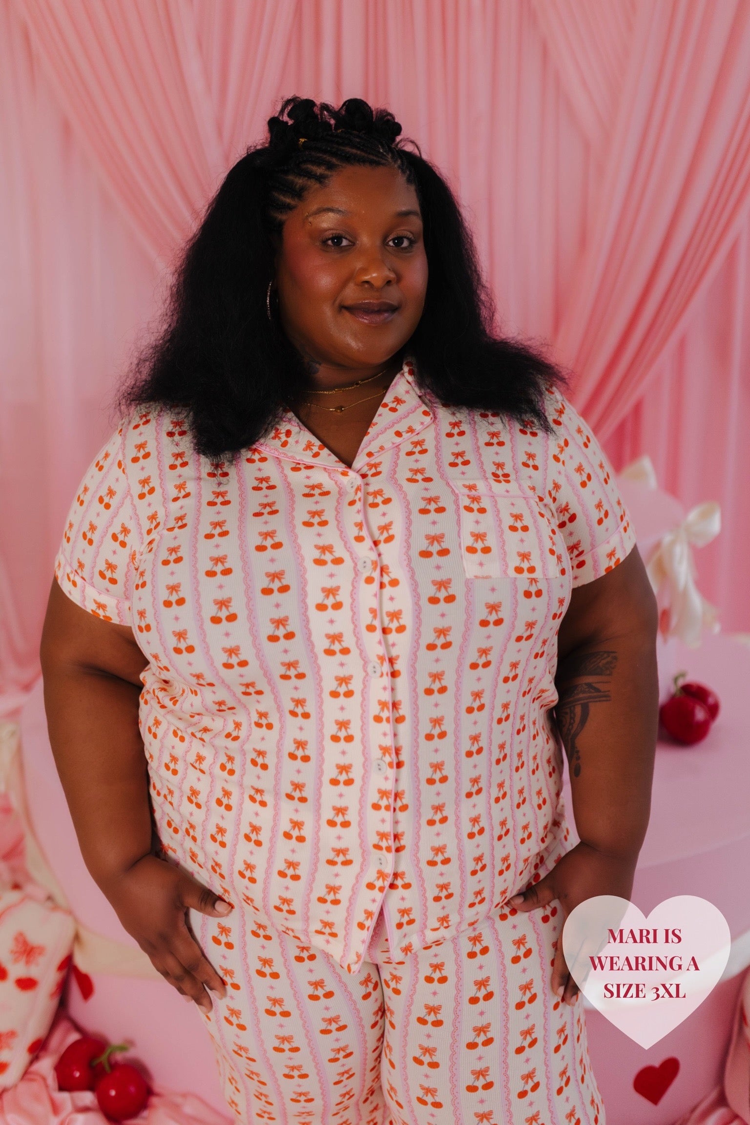 Mari modeling the 3xl with a pink background 
