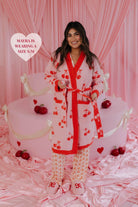 Mayra showing the tie of the robe by holding it in front of the cake set up