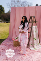 Woman in a pink floral robe standing in front of pink