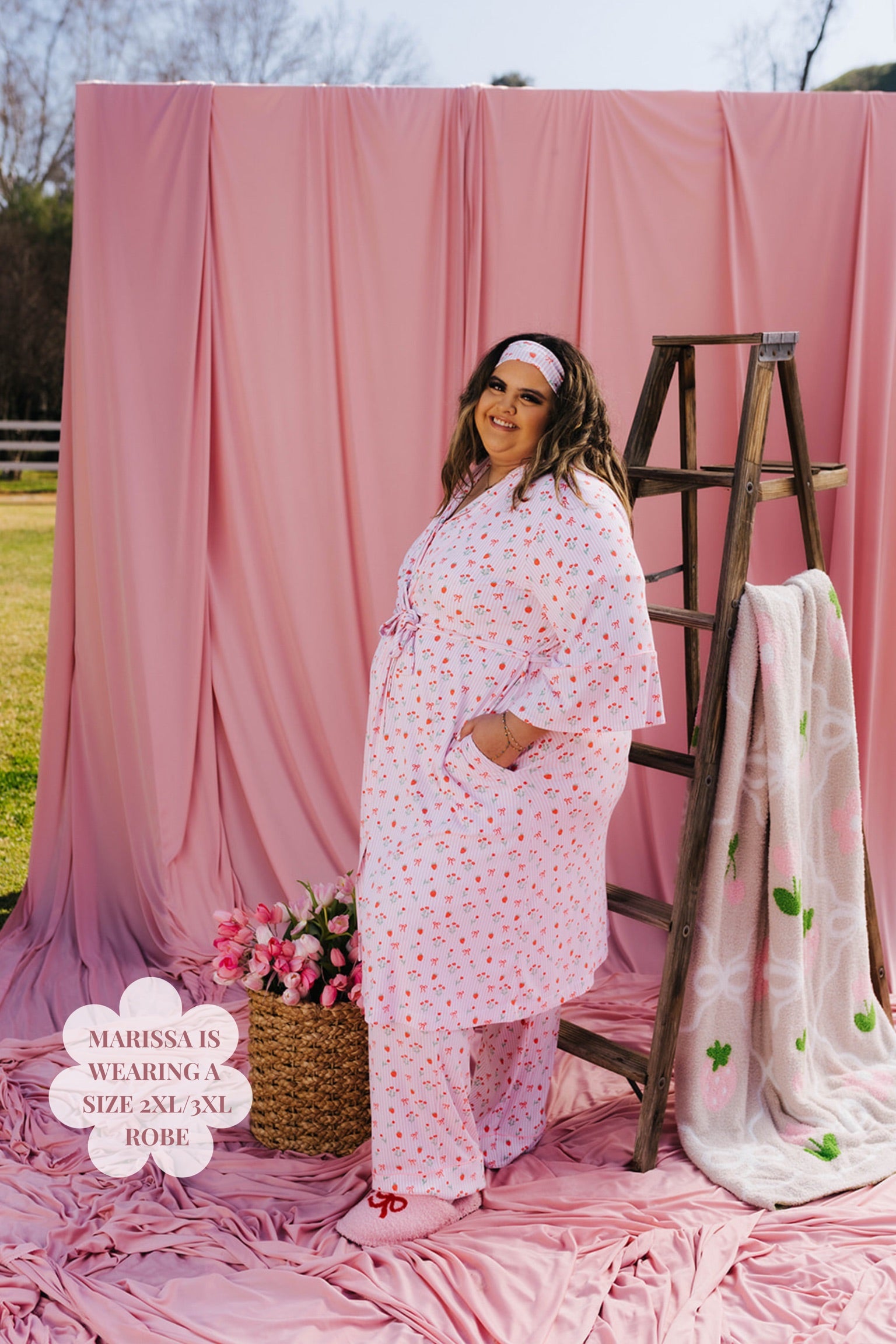 Woman in a pink floral robe standing next to a ladder