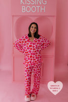 Krista smiling at the camera in front of the kissing booth in the size L pjs
