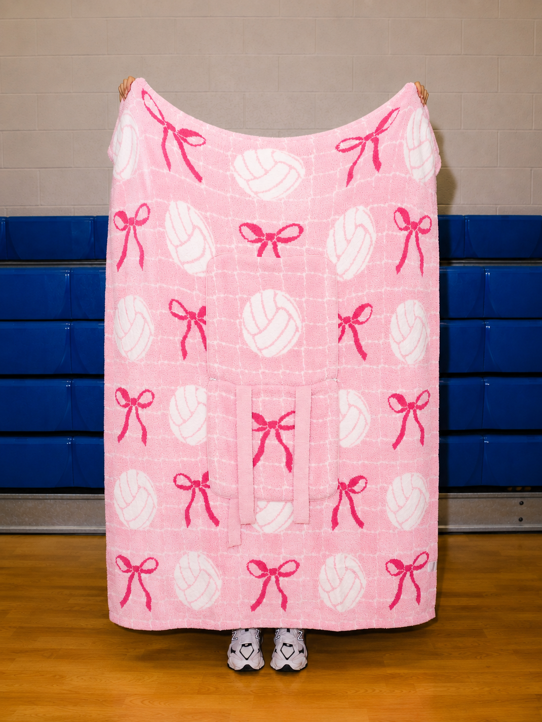 pink quillow full blanket size with a white net in the background and volleyballs and bows
