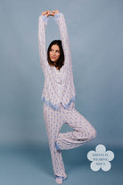 Woman wearing a patterned pajama set against a plain background size L