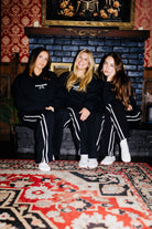 Three models wearing matching Spooky Season sweatshirts