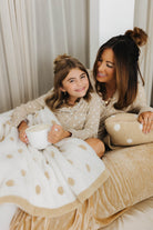 model kolly smiling at camera with model krista smiling at kolly laying on bed
