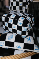Checkered cosmetic bag on top of checkered picnic quillow