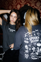 Two models showing the front and back of the Spooky Season tee