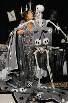 model krista doing kissy faces to skeleton wearing skelly backpack/wristlet quillow and holding the skelly blanket 
