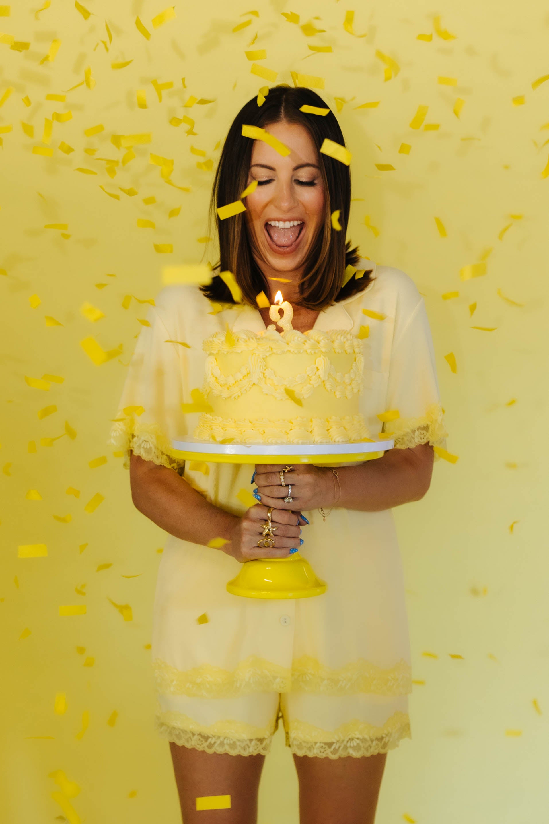 Krista holding a cake with confetti around her