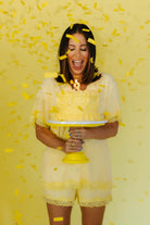 Krista holding a cake with confetti around her