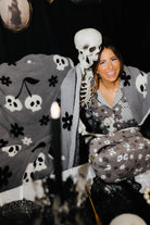 model krista with skelly cosmetic bag and blanket wrapped around her with skeleton arm over her 