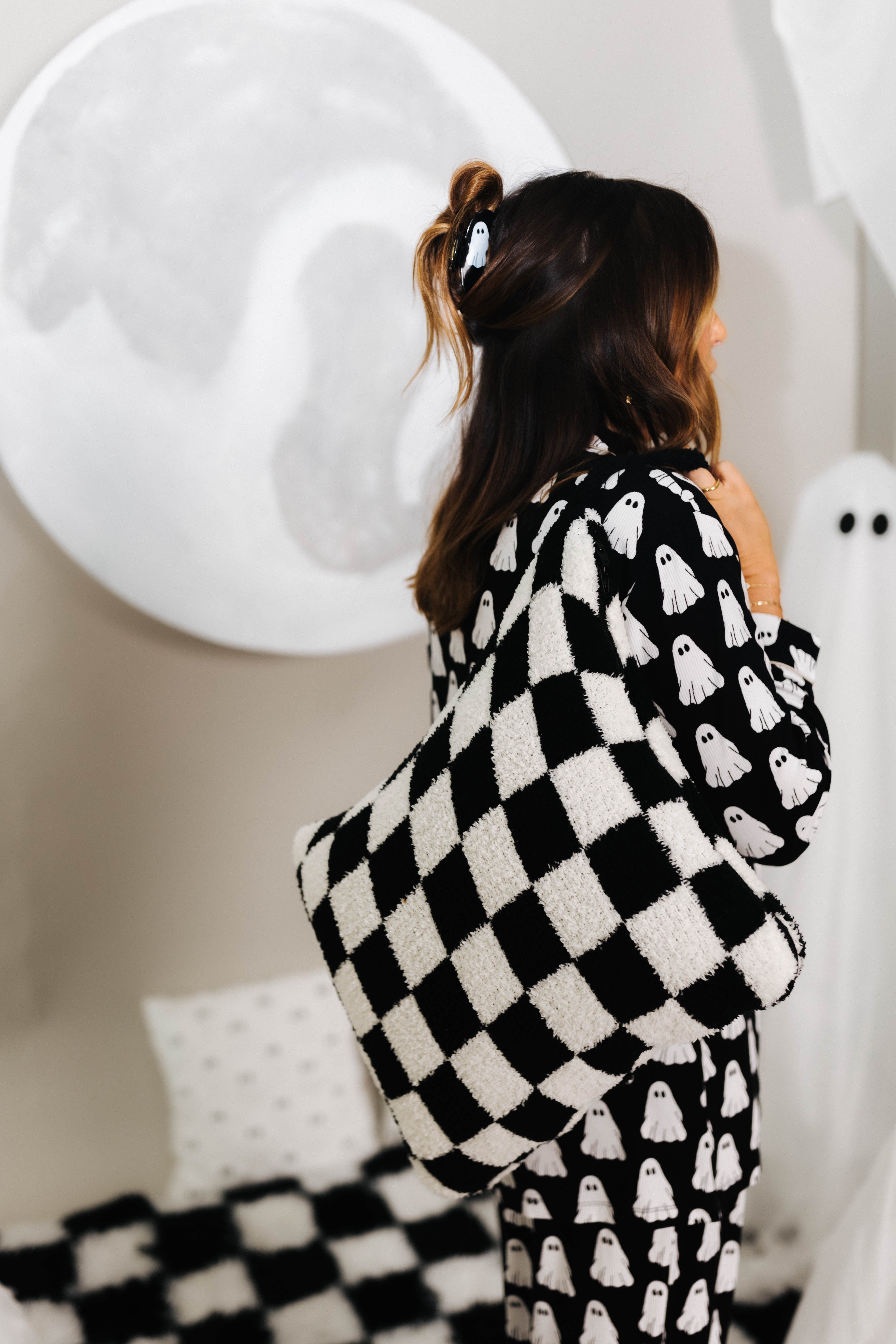 model krista wearing ghost pajamas hanging black check quillow over shoulder