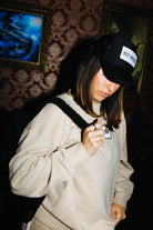 Black Hot Mess hat styled with a matching patch sweatshirt