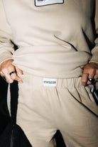 Close view of the tan sweatpants waistband label