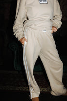 Tan sweatpants shown with hands in the pockets