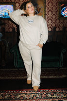 Staykation Halloween collection lifestyle photo featuring Tan 100% Cotton Hot Mess Patch Sweatshirt and Tan 100% Cotton Sweatpants
