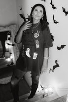model krista in the staircase wearing hot ghoul halloween tee with halloween graphics and candles and bat decorations in the background - black and white photo