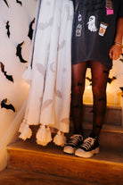 model wearing hot ghoul tee and tights with converse holding the bat blanket showing the tassels 
