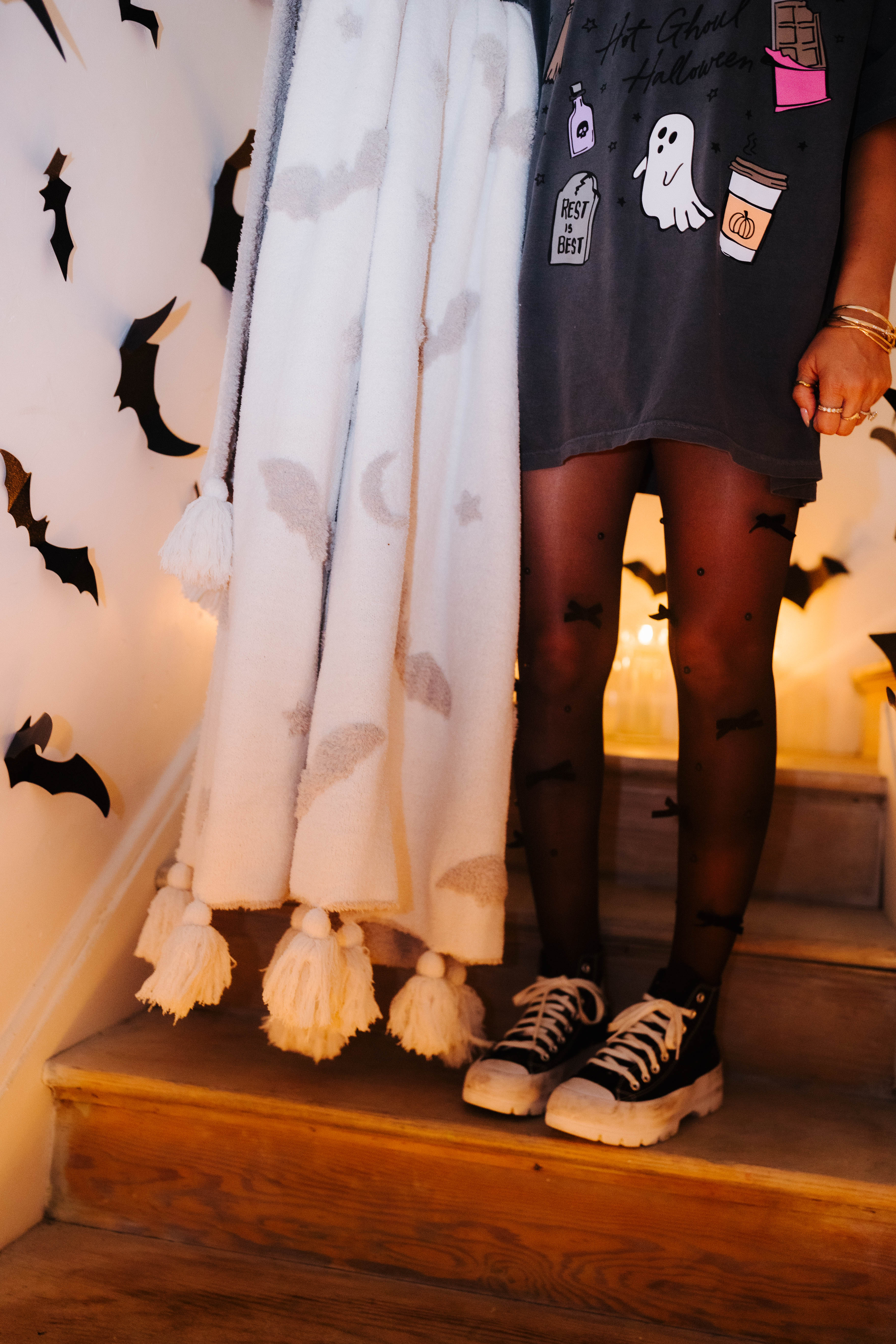 model wearing hot ghoul tee and tights with converse holding the bat blanket showing the tassels 