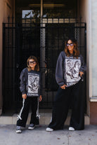 models wearing haunt mess express sweatshirts outside in the street 