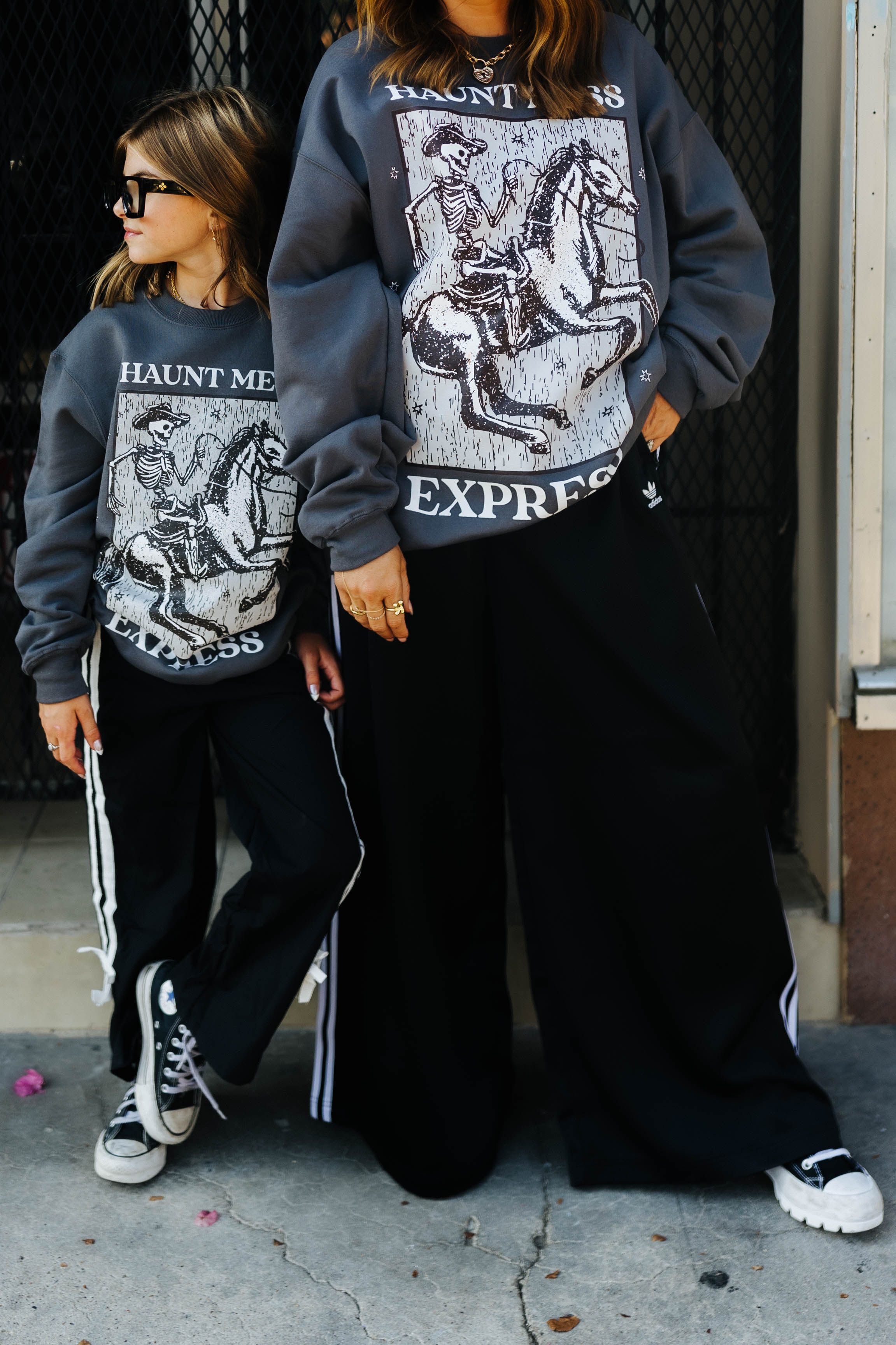models krista and kolly wearing haunt mess express sweatshirts outside on street 