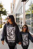 models wearing haunt mess express sweatshirts outside in the street 