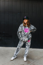 model smiling wearing hot mess at heart camo set and dark green hot mess at heart hat against black wall 